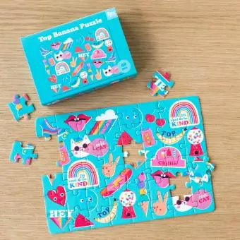 Small jigsaw puzzle with retro style Top Banana print being put together on table