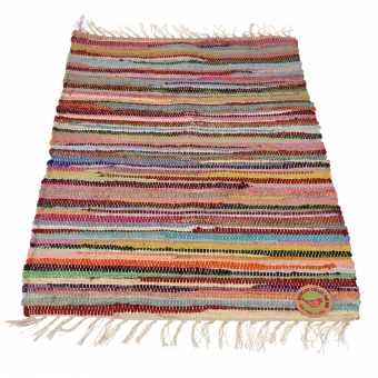Multicoloured handloomed cotton rug laid flat with swing tag showing