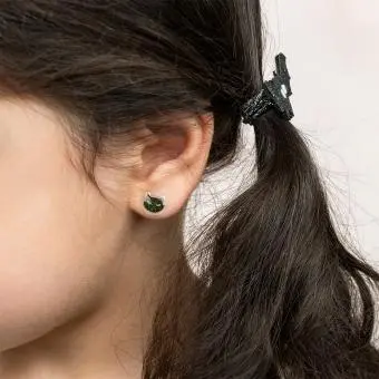 girl wearing small black cat-shaped earring