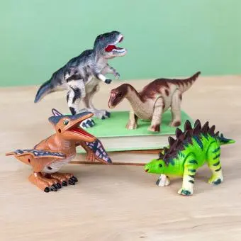 four dinosaurs - Pterodactyl , Stegosaurus, Tyrannosaurus rex and Brontosaurus side by side