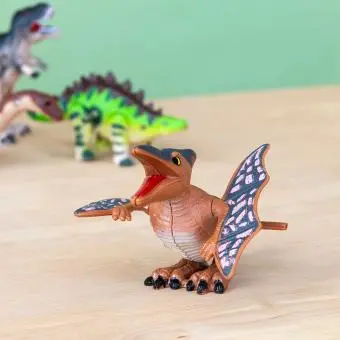 Pterodactyl wind up toy and a green Stegosaurus in the back