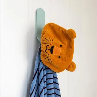 Lion-themed orange bath hat with ears hanging on a wall