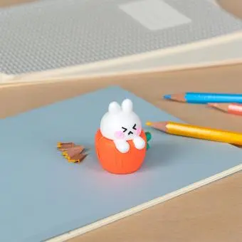 Rabbit-shaped pencil sharpener with coloured pencils placed beside