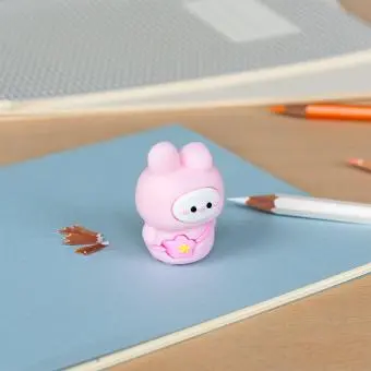 pink bunny shaped pencil sharpener with coloured pencils placed beside