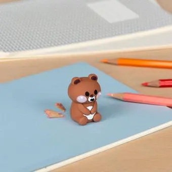 bear shaped pencil sharpener with coloured pencils placed beside 