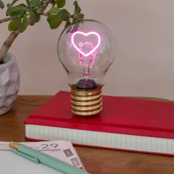 Heart usb light bulb placed on a book with light on