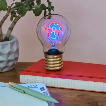 Mushroom usb light bulb placed on a book with light on