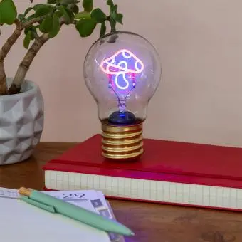 Mushroom usb light bulb placed on a book with light on