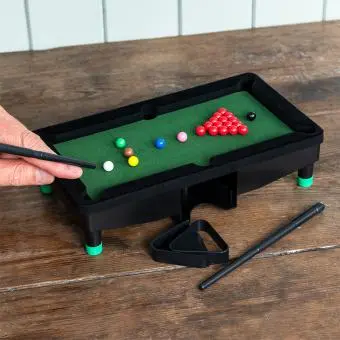 Table top snooker game set up with balls, cues, and rack 