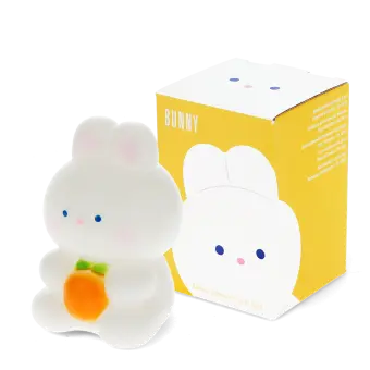 White bunny night light with an orange carrot, shown next to its yellow packaging box
