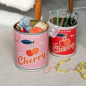 Two large cherry tins used for storing craft supplies.