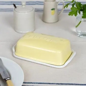 Rectangular butter dish with yellow lid embossed with the word 'BUTTER