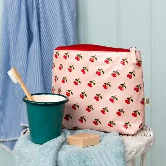 Wash bag in pink featuring colourful illustrations of red cherry print 