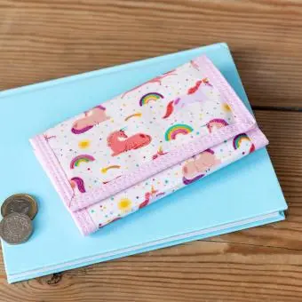 Wallet in pink featuring colourful illustrations of unicorns, rainbows and stars 