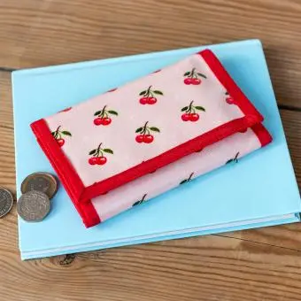 Wallet in pink featuring colourful illustrations of red cherry print 