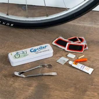 cyclist puncture puncture repair kit beside a storage tin