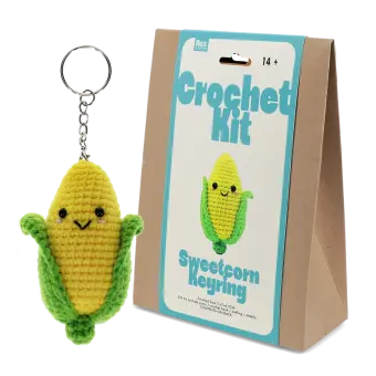 Crochet kit packaging displayed next to a finished yellow and green leaf sweetcorn keychain