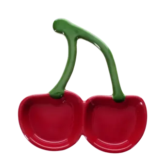 Red ceramic trinket dish shaped like two cherries with green stems.