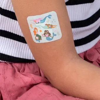 Plaster applied to a kids' hand with a mermaid-themed design.
