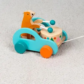 Wooden pull-along toy featuring a bear playing a drum, with colorful wheels