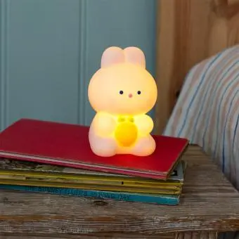 White bunny night light with an orange carrot shown with light on