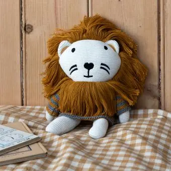 Knitted lion toy wearing a striped sweater, with white knitted legs