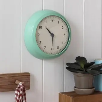 Round mint green wall clock with black hands and numbers
