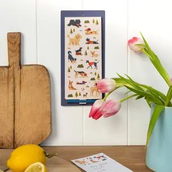 magnetic shopping list pad with dog illustrations hanging on a wall.