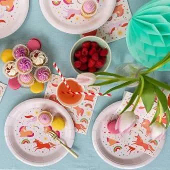 Pink unicorn-themed paper plate displayed with macarons and matching cup and napkin.