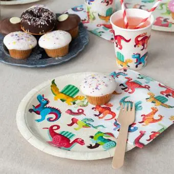 Dinosaur-themed party plate displayes with matching napkins and a cup.