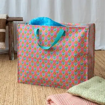 Pink jumbo storage bag with colourful floral designs.