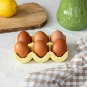 Yellow ceramic egg holder displayed with six eggs