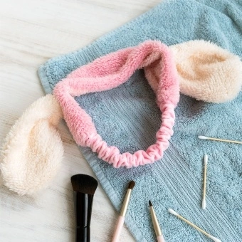Pink plush fabric hairband with soft white bunny ears.