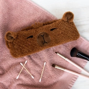 Soft and cosy headband, featuring the friendly face of a capybara. 