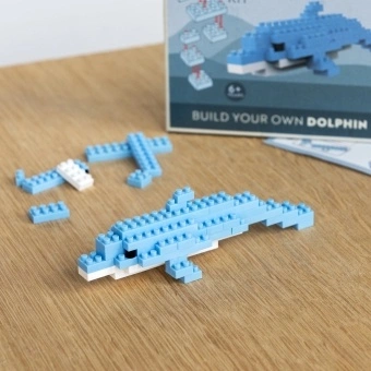 Completed dolphin brick model displayed beside its packaging box.