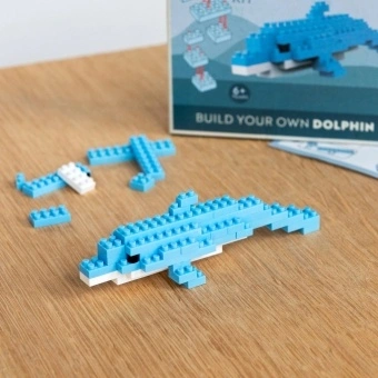 Completed dolphin brick model displayed beside its packaging box.