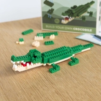 Completed crocodile brick model displayed beside its packaging box.