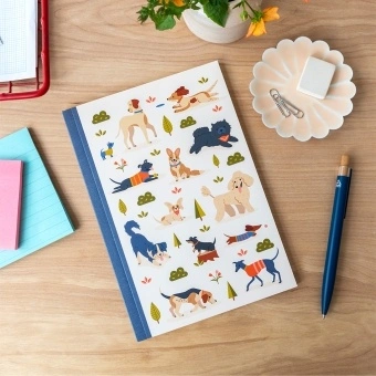 Notebook with illustrated dogs in a park scene on the cover.