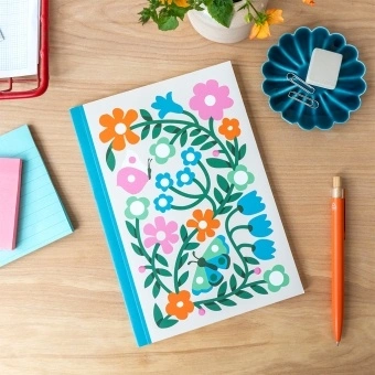 Notebook with colourful illustrated flowers, leaves, and butterflies on the cover.