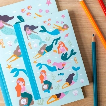 Notebook with illustrated mermaids, sea creatures, and shells on a light aqua cover.