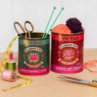 Two Flaming Fox Korean sauce storage tins, one red hot sauce and one green bibimbap design