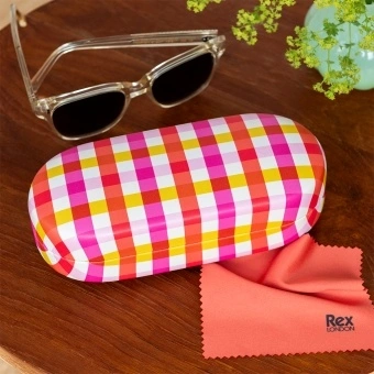 Pink gingham-patterned sunglasses case with cleaning cloth on a wooden table.