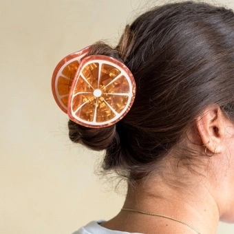 Hair claw clip featuring a fruity orange slice design, with hints of marbling and translucence. 