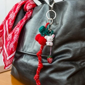 Red knotted cord keyring charm with bunny pendant, and strawberry detail.