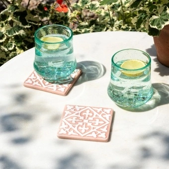 Set of two ceramic drinks coasters featuring an elegant embossed pattern, reminiscent of traditional tile designs.