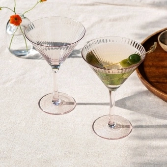 Two pink ridged martini glasses with elegant stemmed design.