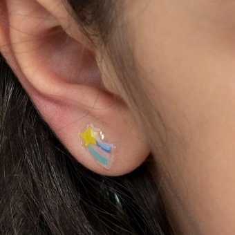 Stick-on earrings in rainbow shape on a kid’s ear