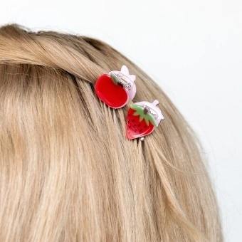 Set of two mini fruit-shaped hair claw clips in strawberry and apple designs.