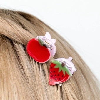 Set of two mini fruit-shaped hair claw clips in strawberry and apple designs.