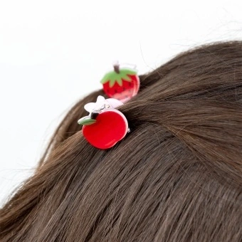 Set of two mini fruit-shaped hair claw clips in strawberry and apple designs.